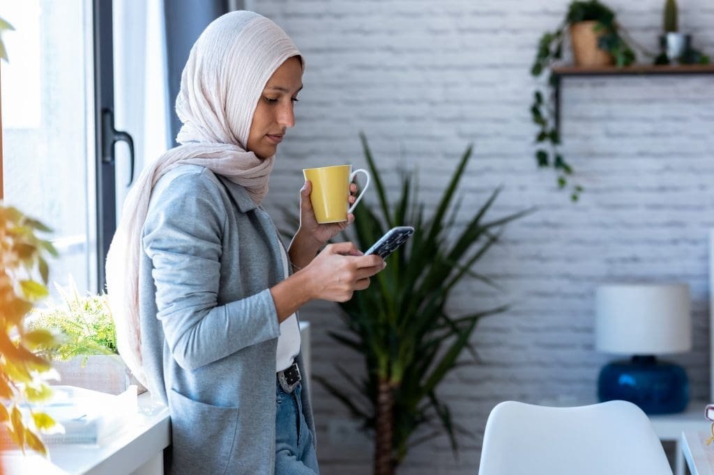Beauty muslim business woman reviewing perimenopause lab results using mobile.