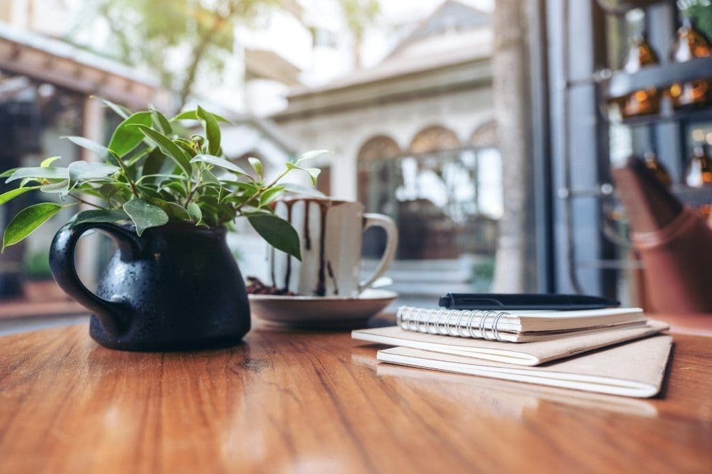 Notebooks, pen and coffee cup on wooden table