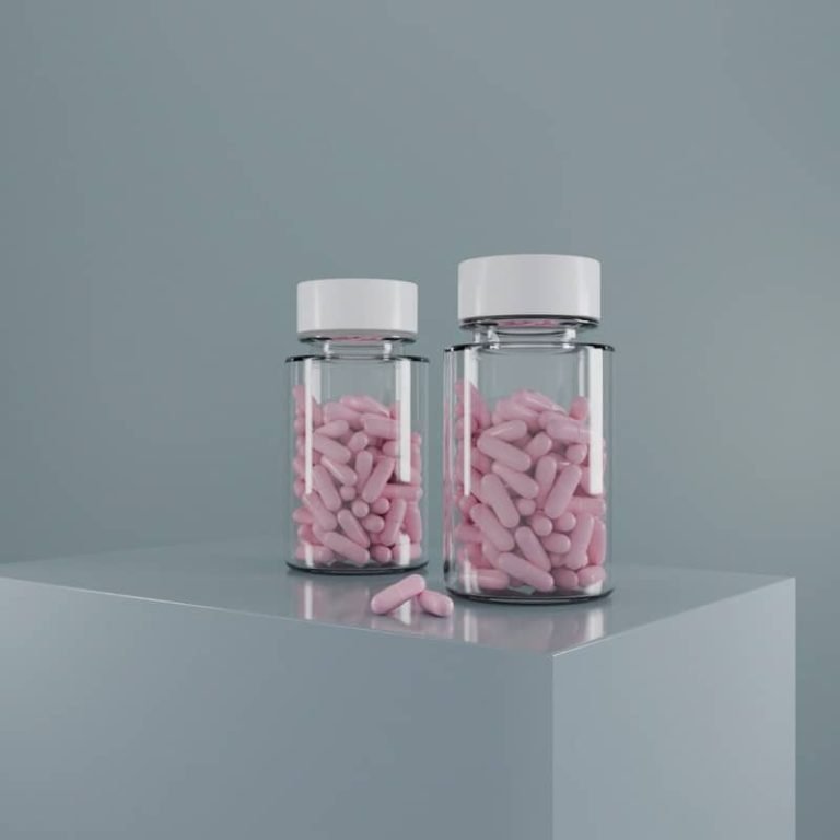 Two pill bottles filled with pink medication.